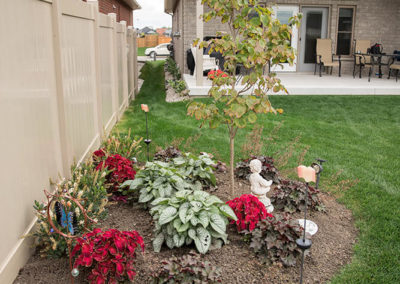 Backyard flower bed with a mix of perennial and annual plants