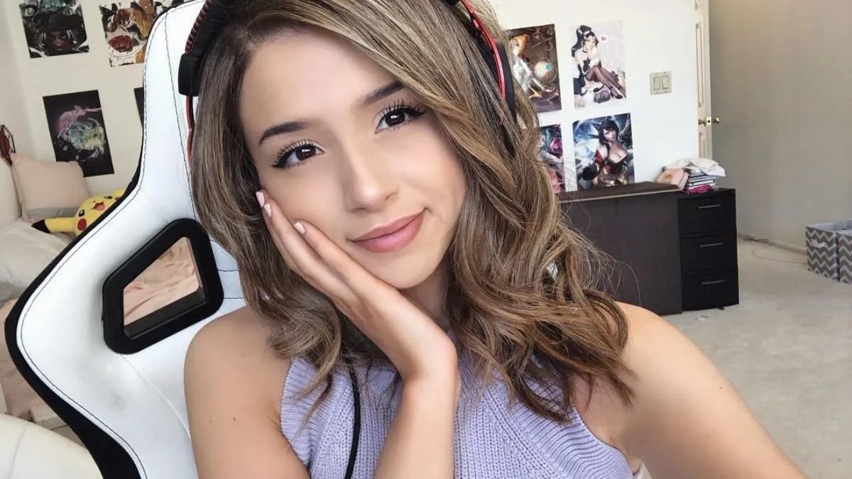 Pokimane putting a hand on her cheek while posing for a selfie