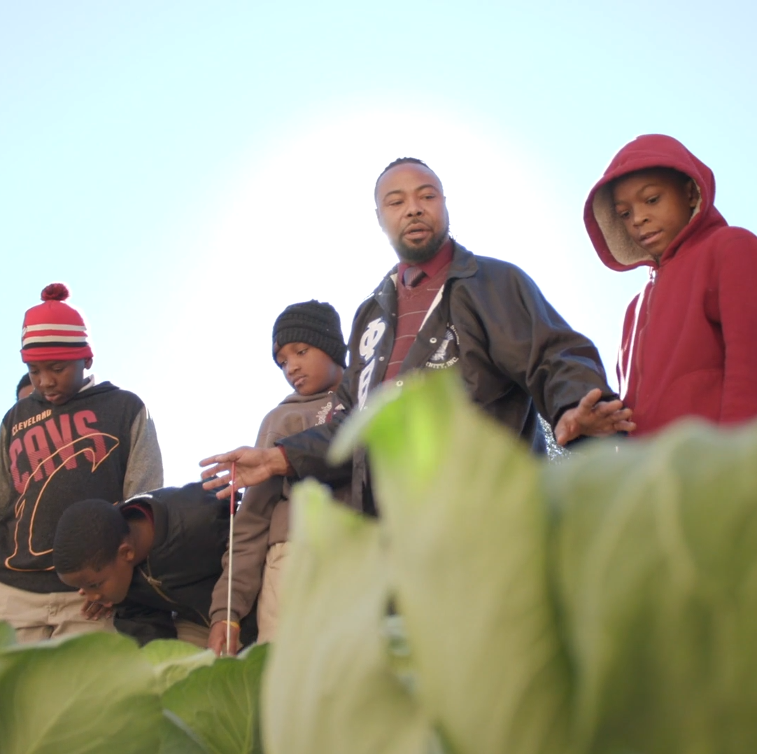 Teacher and students in vegetable garden