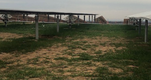 a grass field with a structure in the background