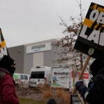 Strikers hold signs during a strike at Skokie (DIL7) Amazon Delivery station in Skokie, Ill.