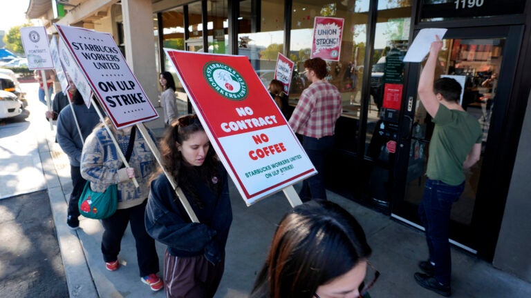 Starbuck workers picket outside of a closed Starbucks in California.