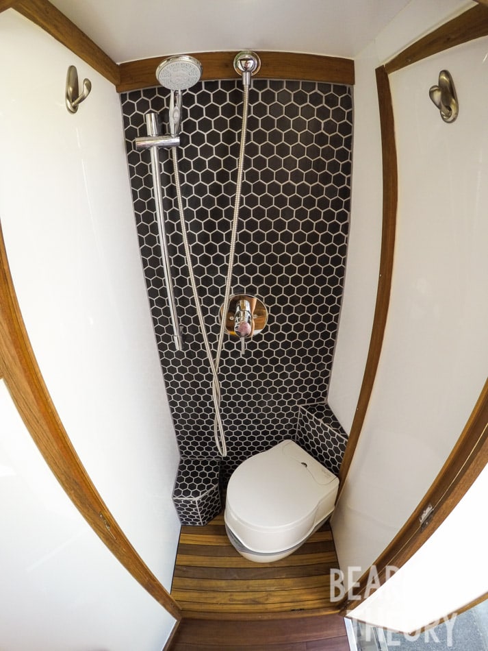 Interior of the floor to cieling custom bathroom with a shower and porta-potti in Kristen's first Mercedes sprinter camper van