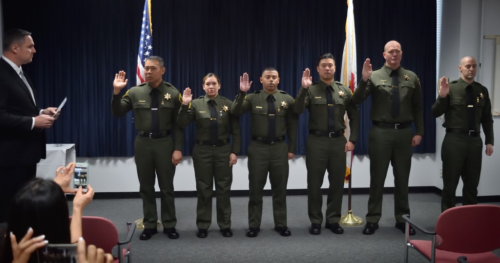 Orange County Sheriff Deputies being sworn in by Undersheriff Don Barnes, left, are from left, Steve Nhek, Melinda Reyna, Matthew Jonte, Bongki Min, Arvar Elkins and Arthur Paine. Photo by Steven Georges/Behind the Badge OC