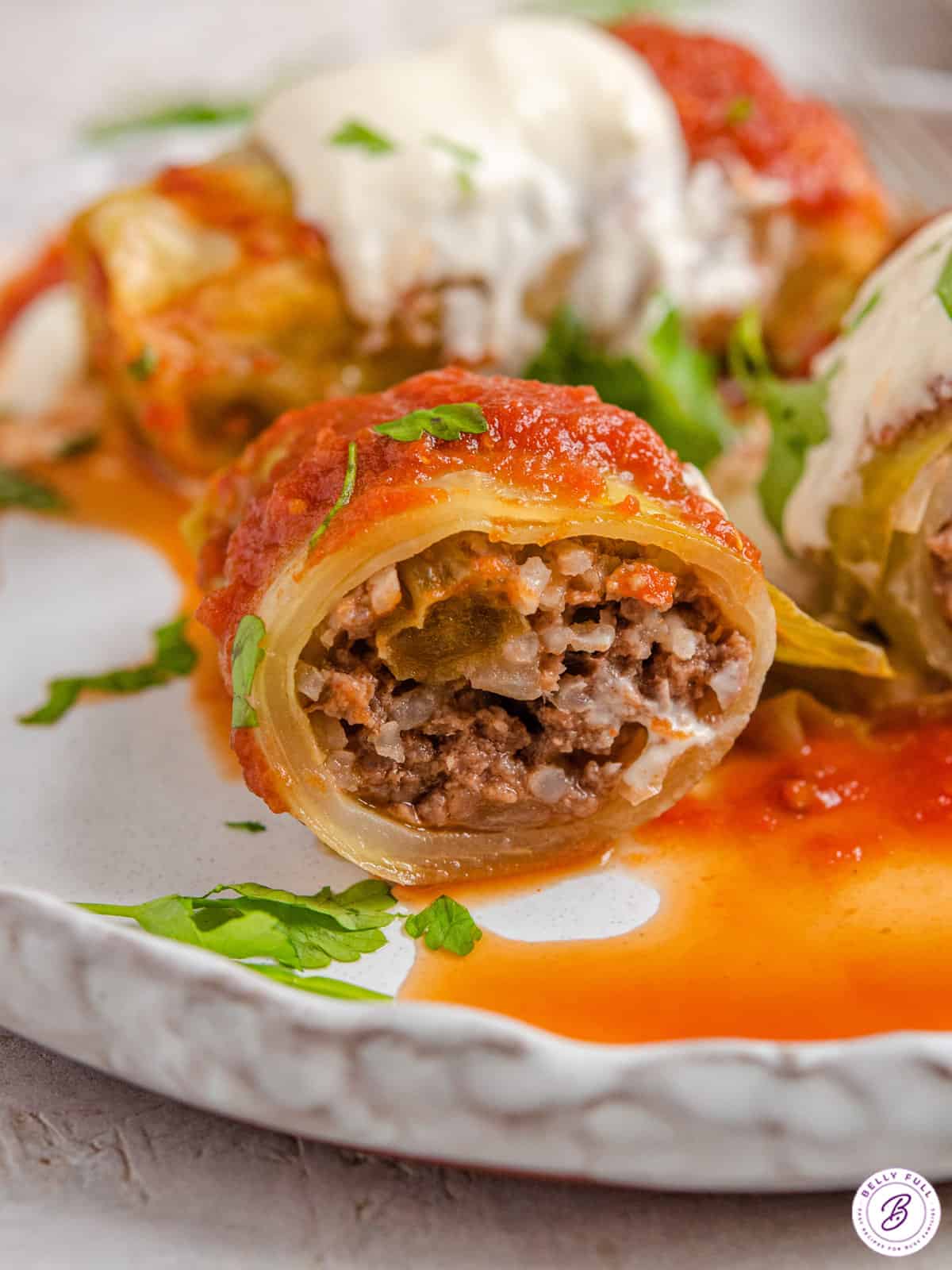 close up beef filled cabbage roll on plate cut in half