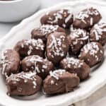 Chocolate covered dates with coconut on a tray