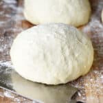 round of pizza dough on cutting board