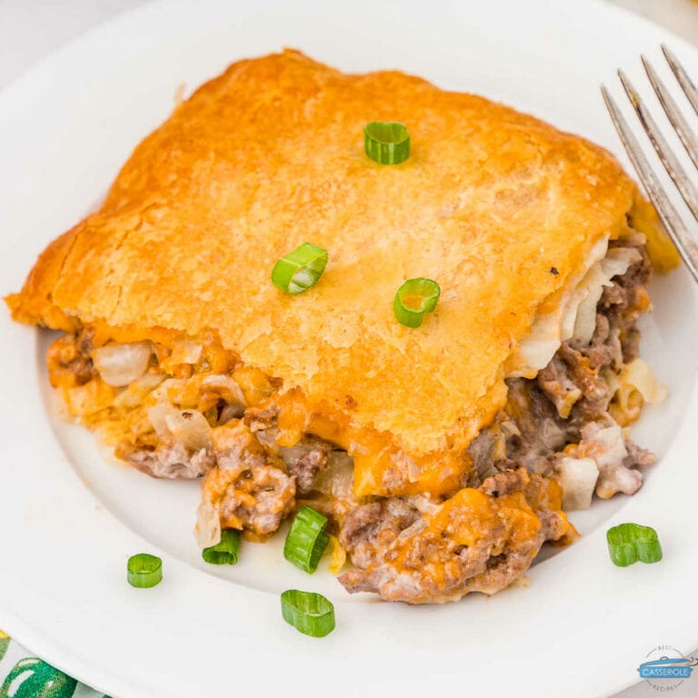 square of Bierock casserole on a white plate with fork and garnished with green onions