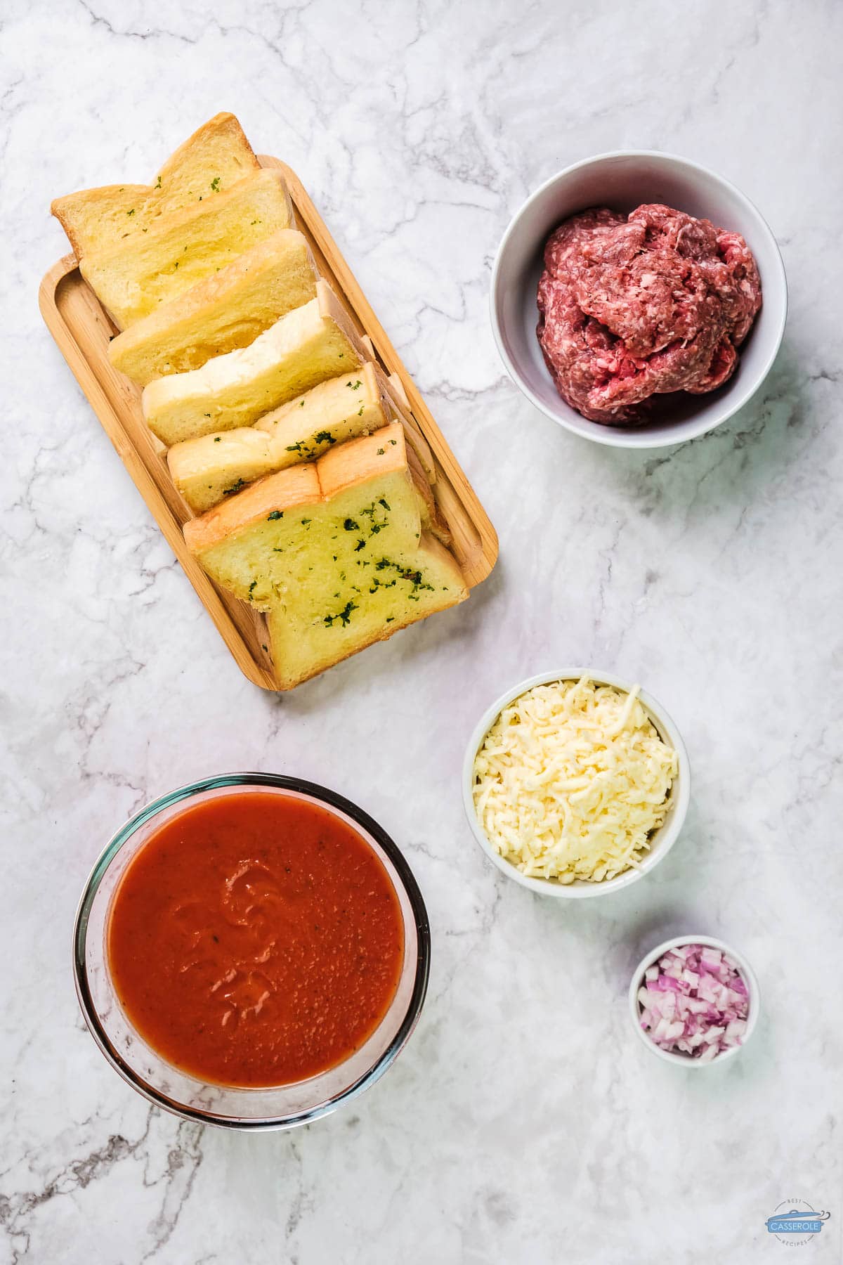 ingredients for garlic bread casserole on a marble backdrop