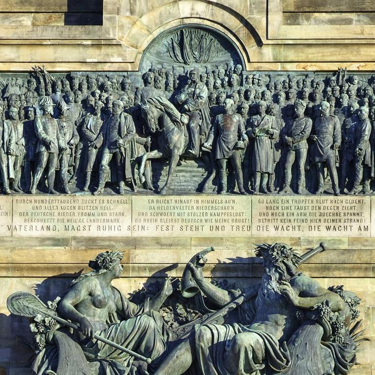 Niederwalddenkmal, errichtet 1877-1883 zur Erinnerung an die Neugründung des deutschen Kaiserreichs 1871. Bildhauer Johannes Schilling, Architekt Karl Weißbach. Mittelteil: Bronzerelief mit dem Aufbruch in den deutsch-französischen Krieg 1870/1871 mit König Wilhelm von Preußen (ab 1871 Kaiser Wilhelm I.) zu Pferd und den deutschen Fürsten und Generälen, unten Personifikationen des Rheins und der Mosel. Bronze. Rüdesheim, Deutschland, Hessen, am Rhein.