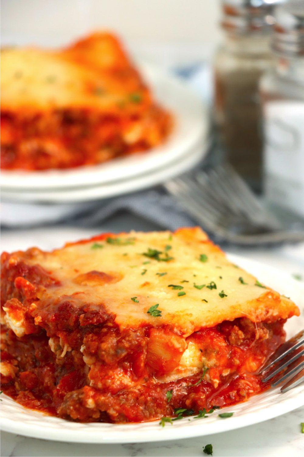 piece of lasagna on white dinner plate