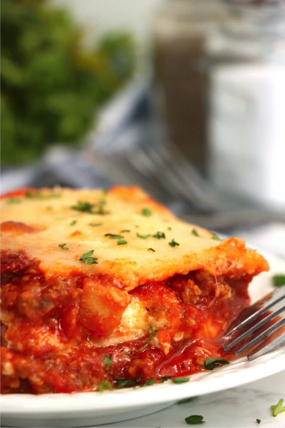 fork digging into a piece of layered lasagna