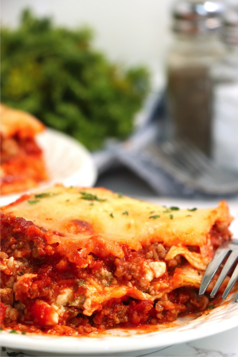 fork laying next to piece of lasagna on a plate