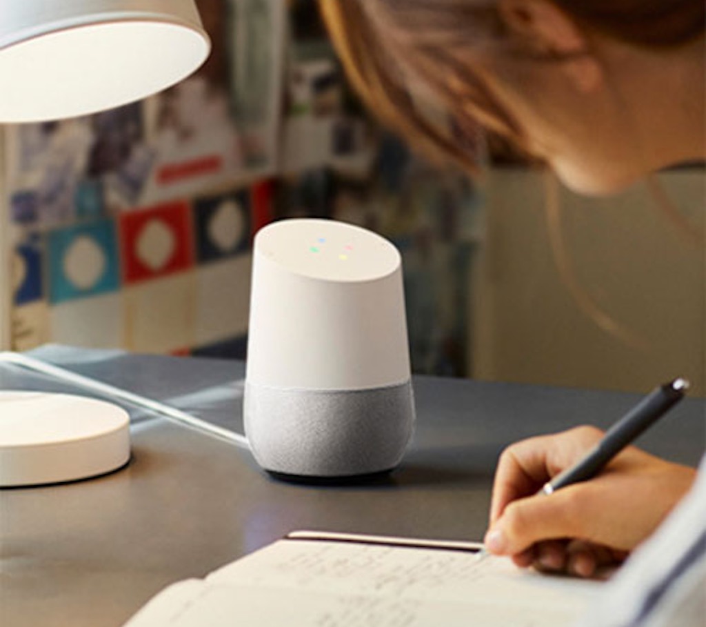 User working on her desk with Google Home next to her