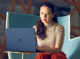 Woman sitting in chair working on HP Elitebook laptop.