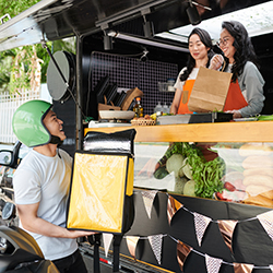 Someone receiving food from a food truck, representing the concept of a food truck fundraiser.