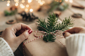 Woman tying bow on holiday gift