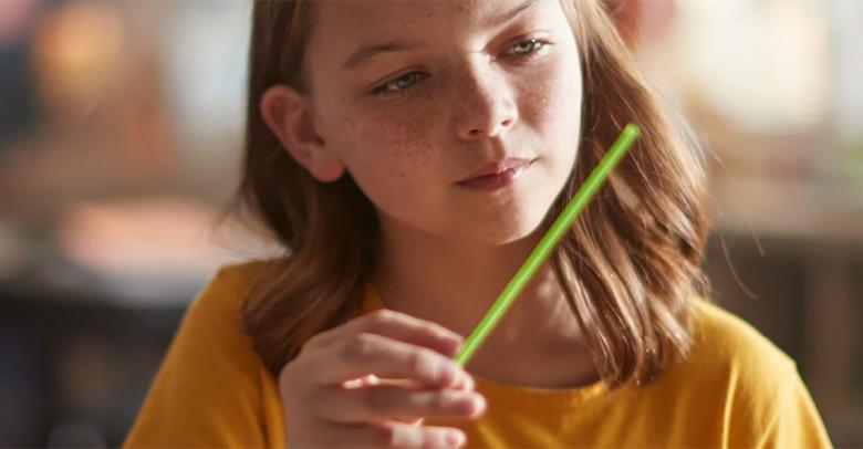 young student looking curiously at a straw