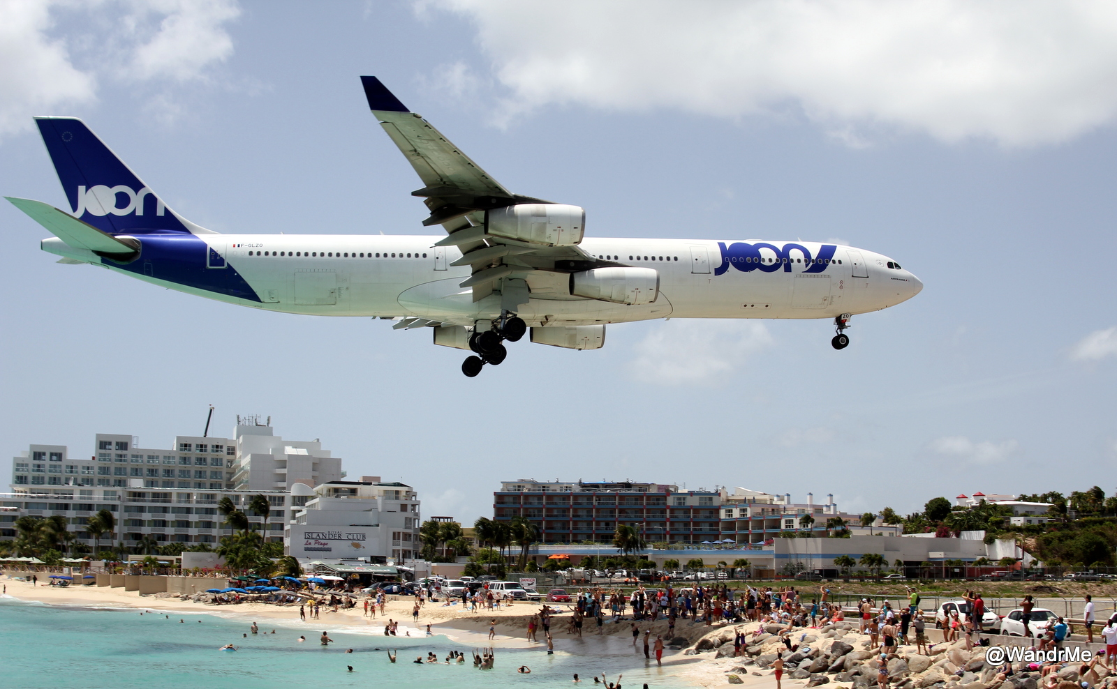 a large airplane flying over a beach