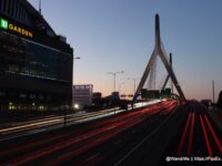 a bridge with a large tower and a building with lights