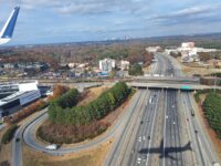 Shadow of a plane crossing over a highway, as seen from inside the plane