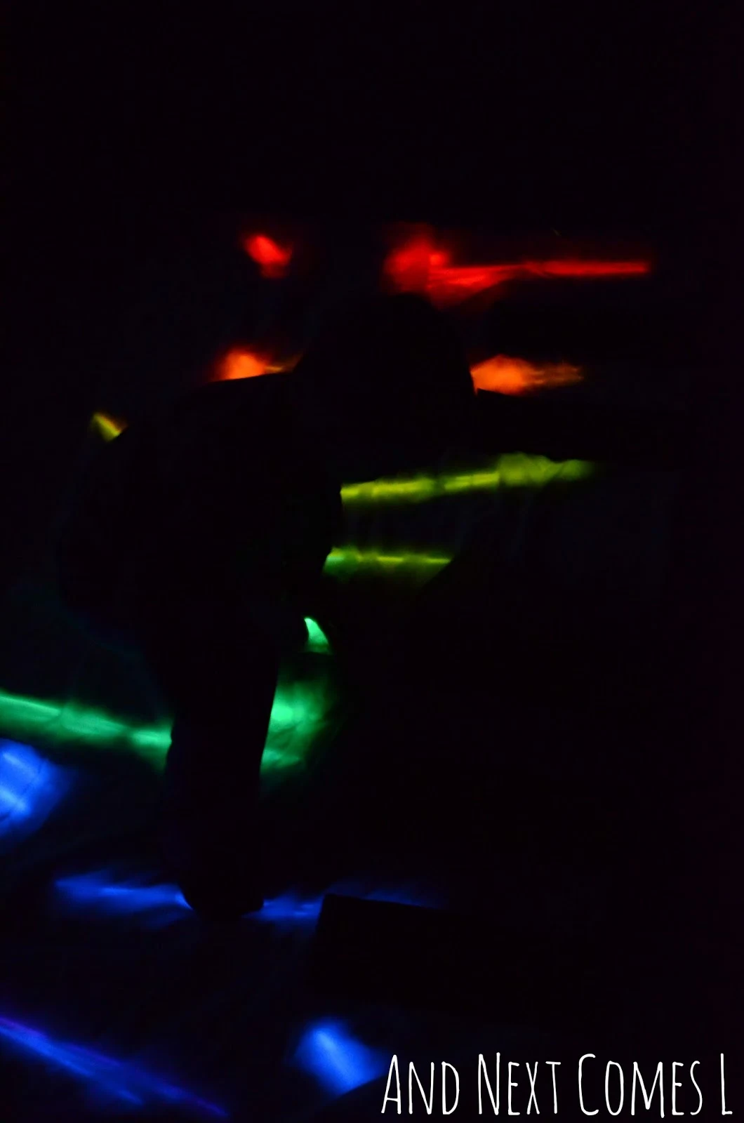 Silhouette against a homemade glowing floor piano from And Next Comes L