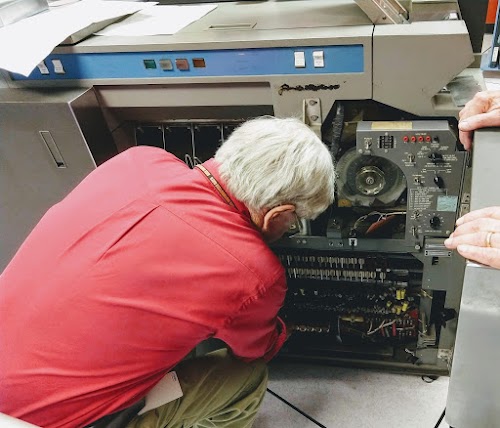 Frank King replacing a bad relay in the 1402 card reader. The relays are next to his right shoulder.