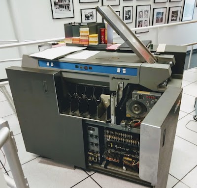 The IBM 1402 card reader at the Computer History Museum. Cards are loaded into the hopper on the right. The front door of the card reader is open, revealing the relays and other circuitry.