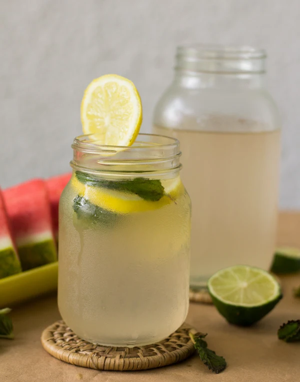 Two mason jars full of Caribbean lime juice with a lime wheel for garnish.