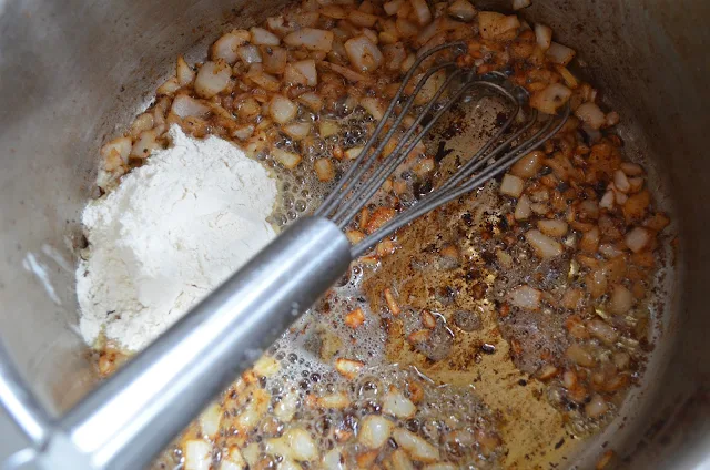 Stir flour and garlic into onions.