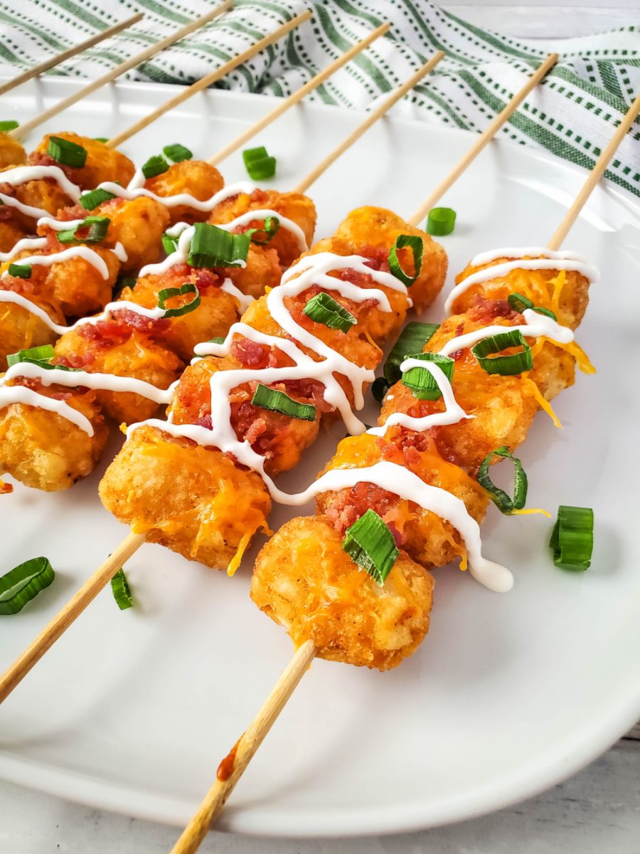 close up of loaded tator tot skewers with sour cream