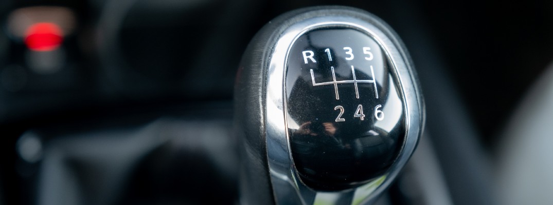 A stock photo of a gear lever in a vehicle with a manual transmission.