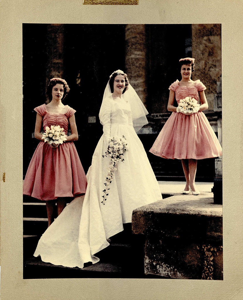 A bride and two bridesmaids in pink 1950s dresses, posed at Blenheim Palace, 1950s