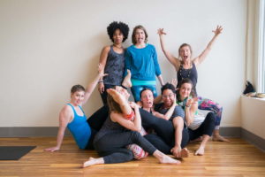 A group of people in yoga poses with playful expressions