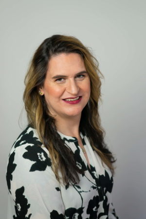 A woman smiles confidently during a business headshot session in Seattle