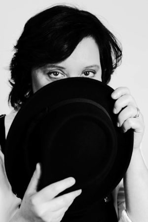 A black and white photo of a fat woman showing just her eyes above a hat