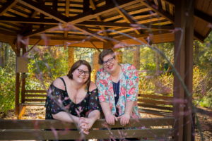 Two people pose together in a gazebo during an LGBT friendly photo shoot