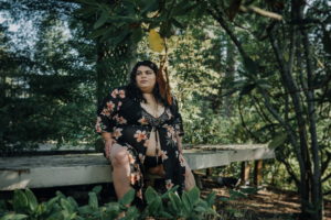 A fat woman looking confidently off camera in a swimsuit outdoors in the PNW