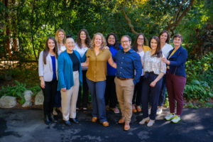 A group of smiling people poses for a small business session in the PNW