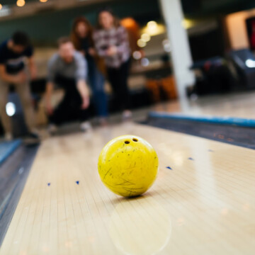 Yellow urethane bowling balls on synthetic lanes at the bowling center