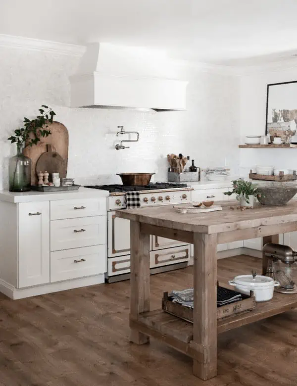 Farmhouse kitchen with wood island, Pergo flooring in Riverbend Oak, White shaker cabinets and french range.