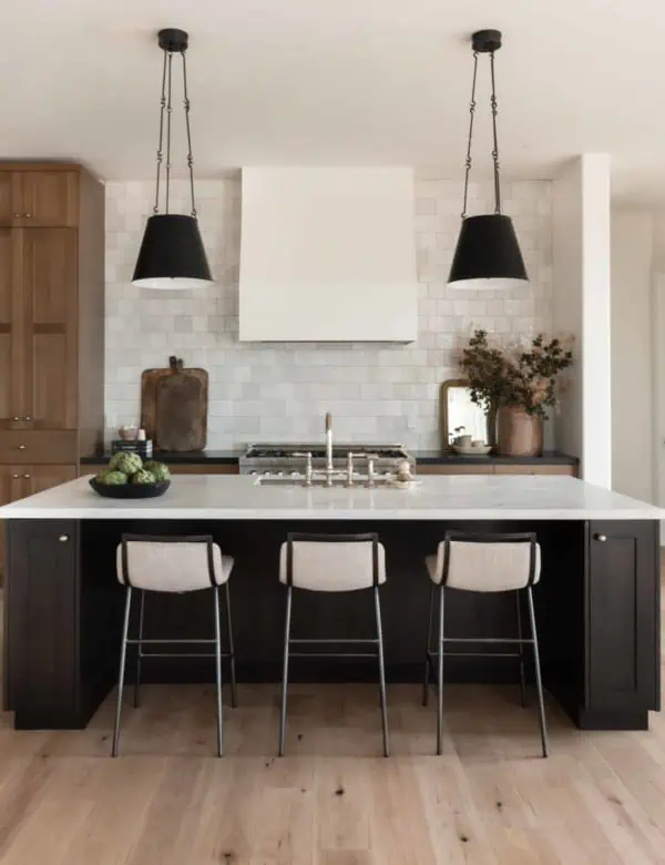 Dream kitchen interior design by Boxwood Avenue Interiors with dark island and white oak cabinets with black pendants and marble countertops.