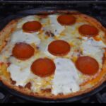 A pizza sitting on top of an oven.