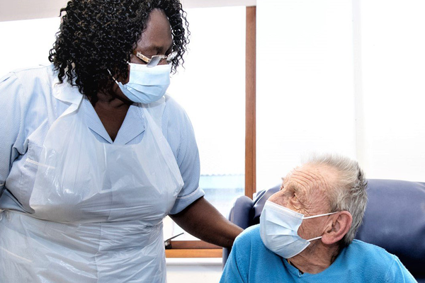 CUH Nurse with patient, both wearing masks