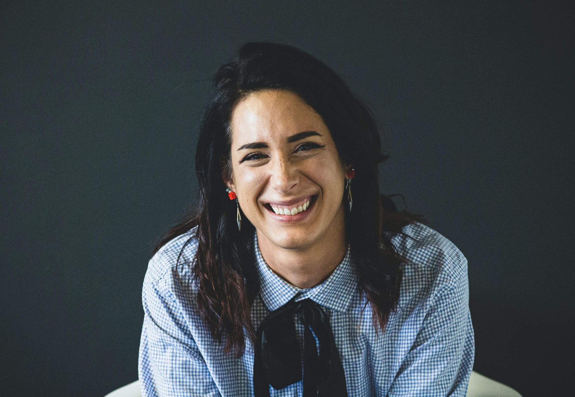 Profile picture of a smiling woman in a black and white checkered shirt