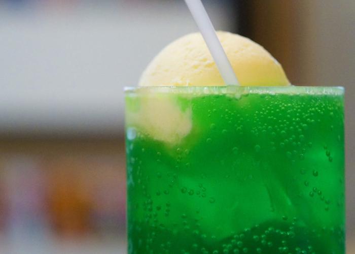 A popular Japanese beverage, a glass filled with vibrant green melon soda