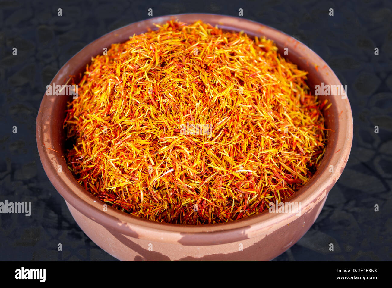 Saffron spice in pot on black isolated background Stock Photo