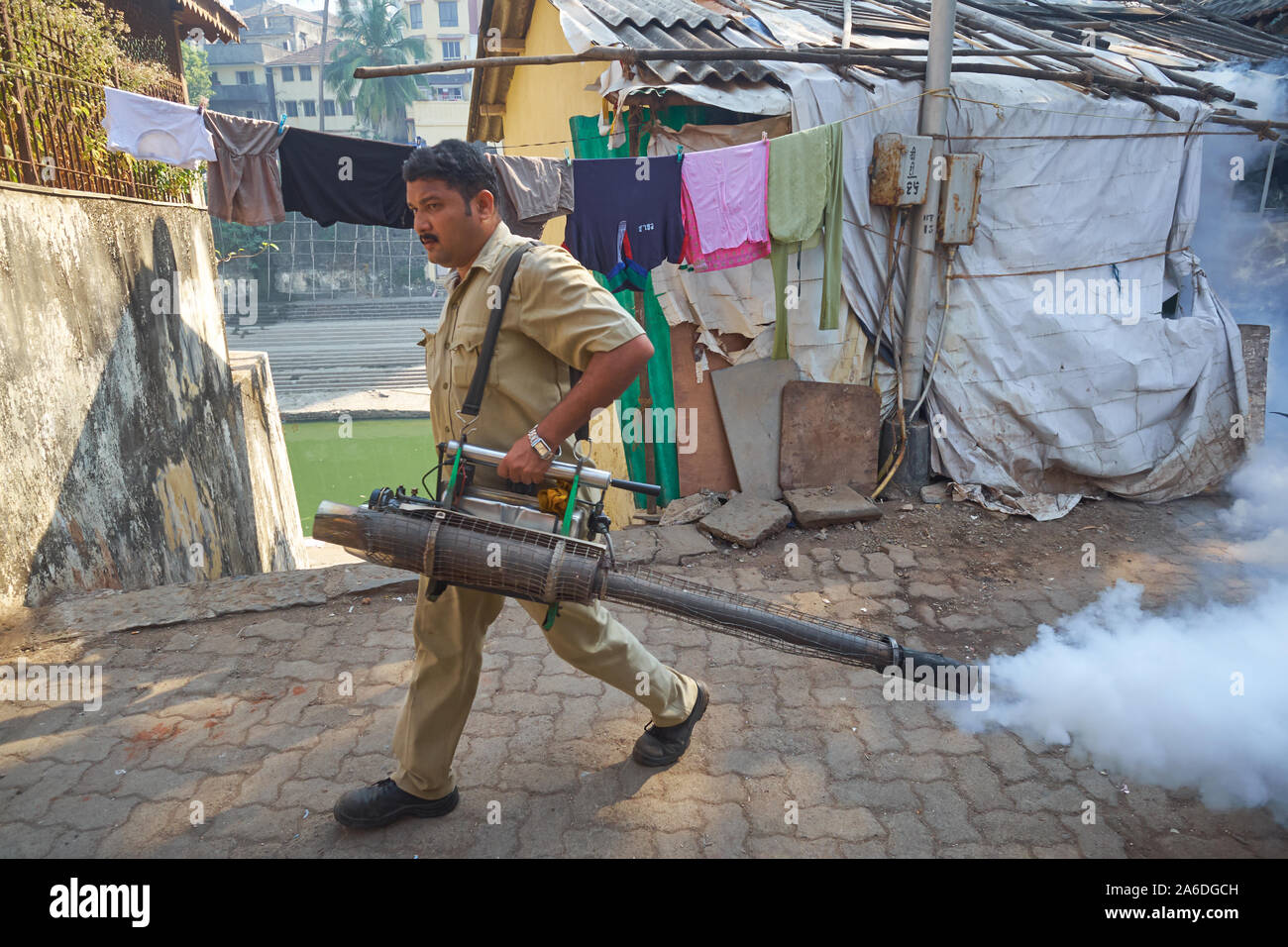 Before the onset of the monsoon, an employee of the Brihanmumbai Municipal Corporation sprays insecticide to fight the mosquito plague; Mumbai, India Stock Photo