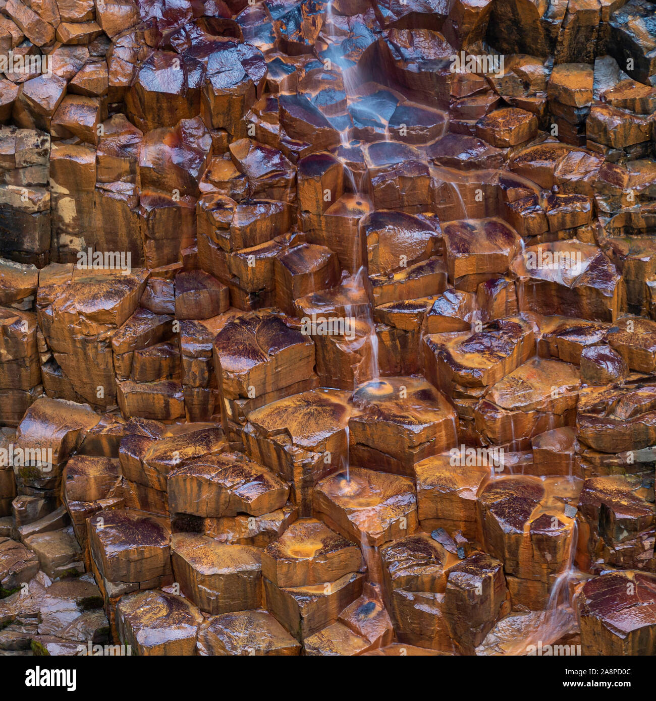 Basalt Columns with water flowing in Iceland Stock Photo