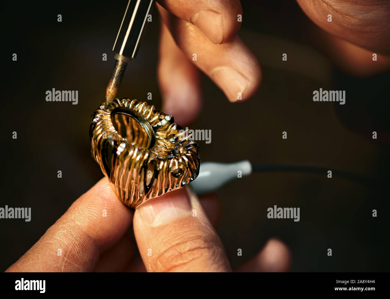 A jeweler is treating a rhodium the gold ring. Stock Photo